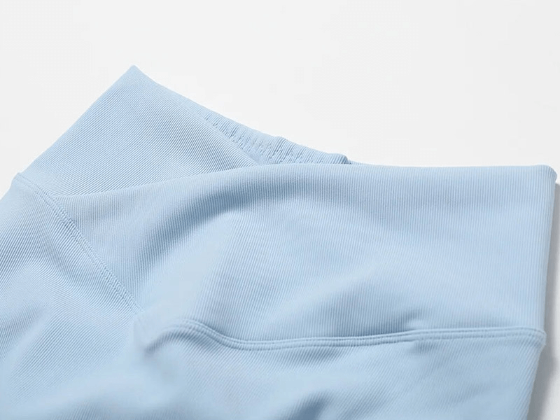 Close-up of light blue ribbed cross leggings, showcasing textured fabric perfect for workouts and active lifestyles.